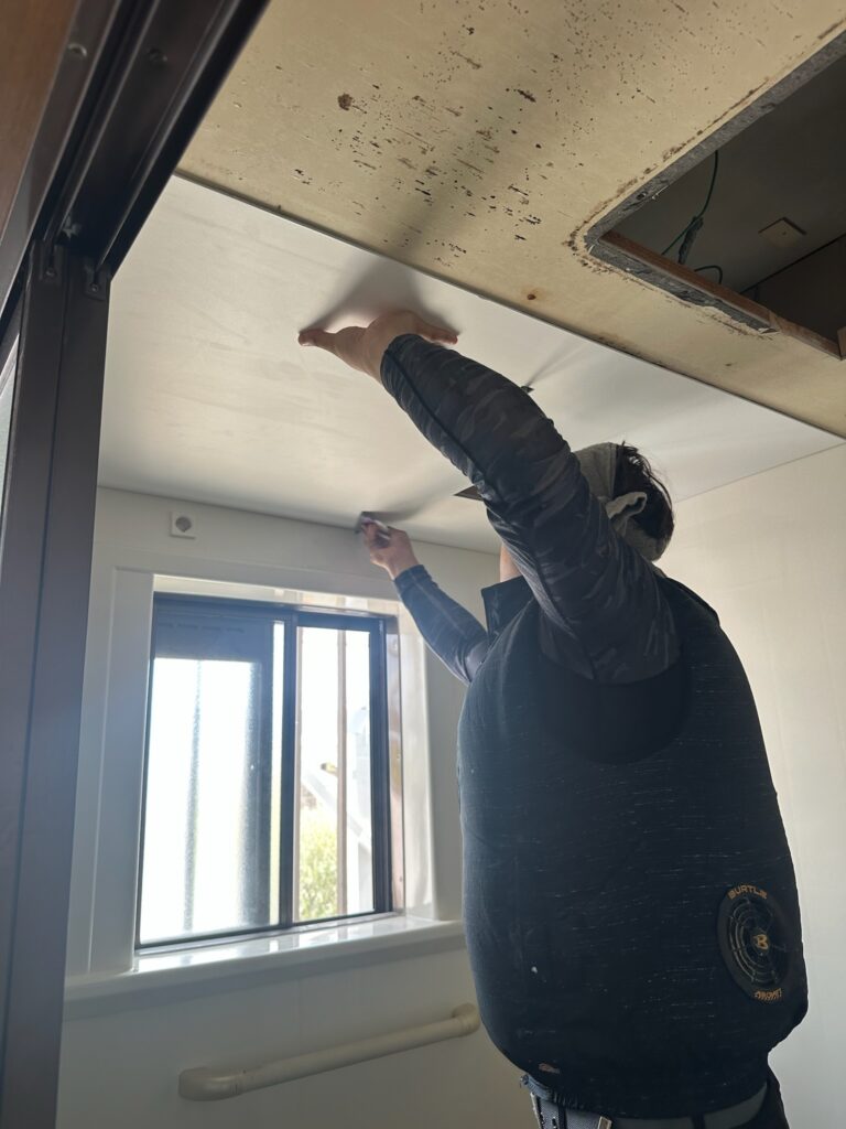 天井に装飾パネルを張り付ける施工作業