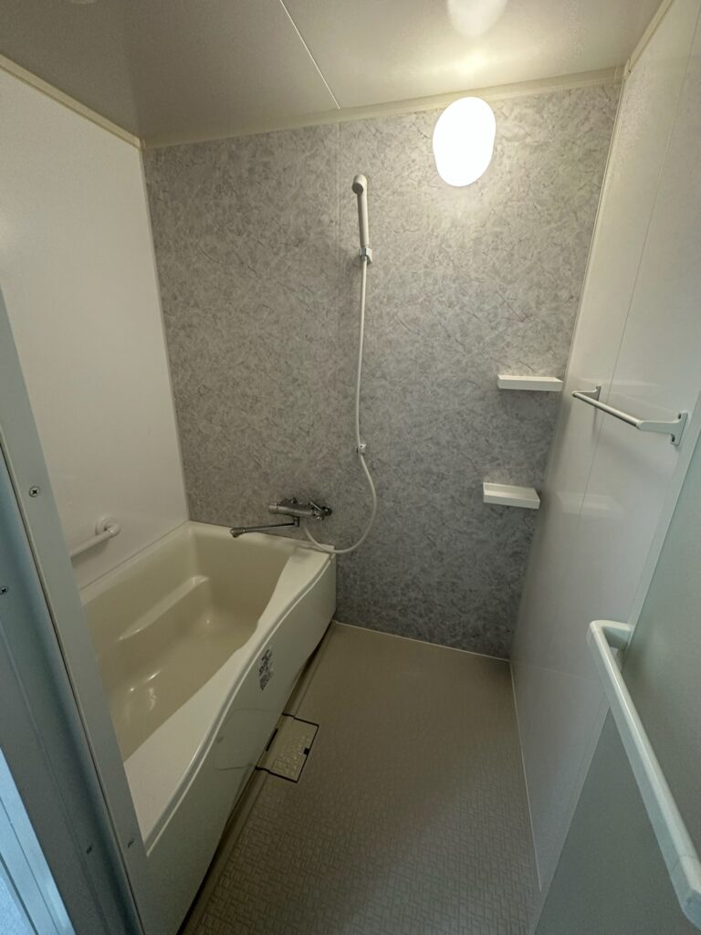 施工完了後の浴室壁。グレー系石目調の仕上がりで美しく違和感がない