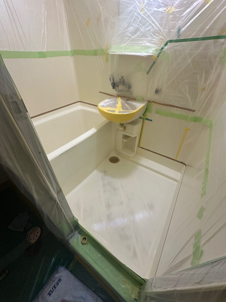 塗装から15年が経過した浴室の下地処理完了後の状態。塗膜の剥がれや浮きが見られず、再塗装に適した良好な下地状態。