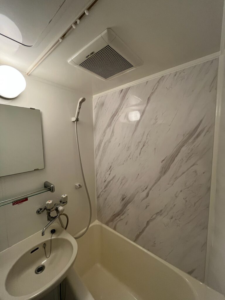 壁1面に大理石風のパネルを張ったユニットバス